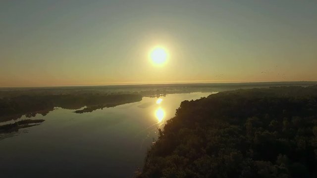 aerial view of river at sunrise 4K, forest and river in morning mist, Very high view of the river forest at sunrise, Aerial view of mystical river at sunrise with fog, sun above the river aerial