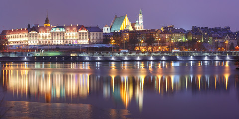 Panorama of the Old Town with reflection in the Vistula River during evening blue hour, Warsaw,...