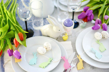 Fototapeta na wymiar Beautiful table setting with crockery and flowers for Easter celebration