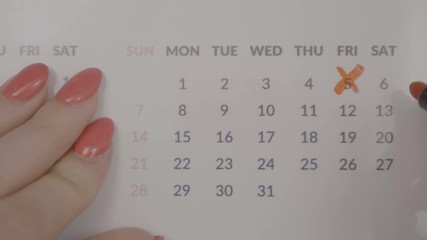 Top view of business woman hands crossing over monthly appointment dates on calendar agenda
