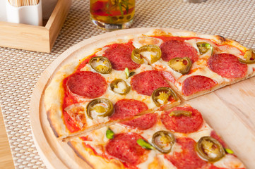 fresh pepperoni pizza in daylight in the cafe