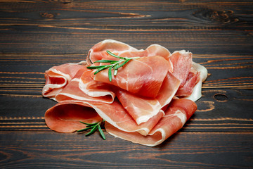 Italian prosciutto crudo or spanish jamon. Raw ham on wooden background