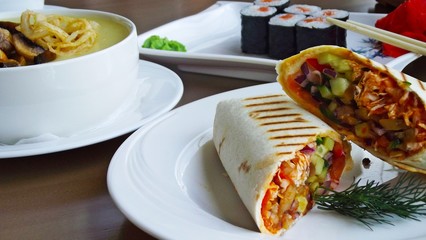 Tasty vegetables in pita bread on a white plate.