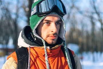 Portrait of male skier in the forest, winter, green cap