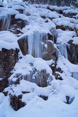 Fototapeta na wymiar Frozen waterfall with rock