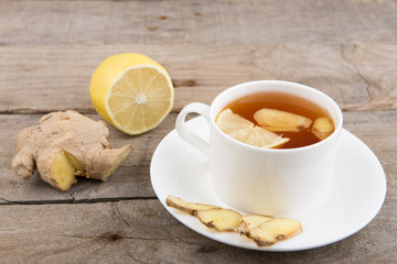 Ginger tea in a cup on wooden background