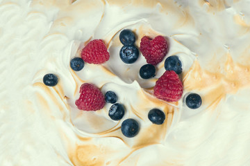 The texture of the meringue cake with blueberries and raspberries