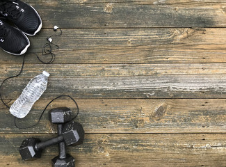 Flat Lay of Black White and Gray Health and Fitness Items on a Neutral Wood Background with Empty Text Space