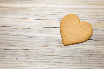 Heart shaped gingerbread on wooden background.
