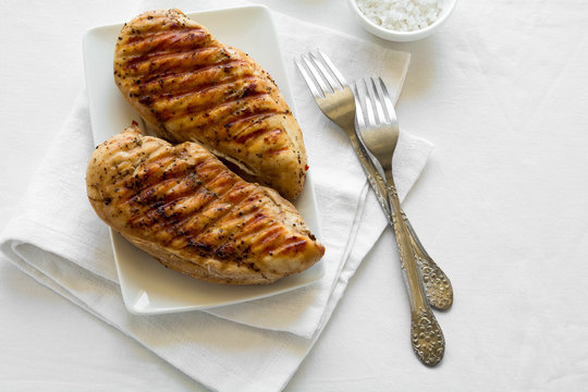 Grilled chicken breast on white table cloth