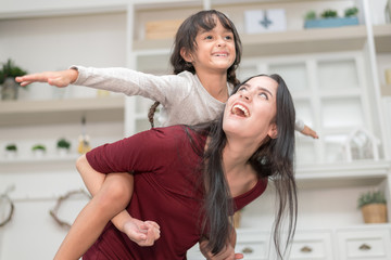 Happy Family spending time together at home.In selective focus of funny ride on back and run around.