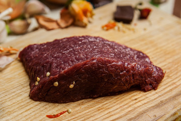 Raw beef with pepper seeds on the cutting board
