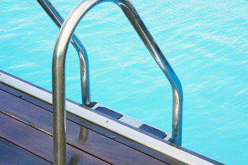 Fototapeta na wymiar Handrails for descent into the pool. Pool cleaner during his work