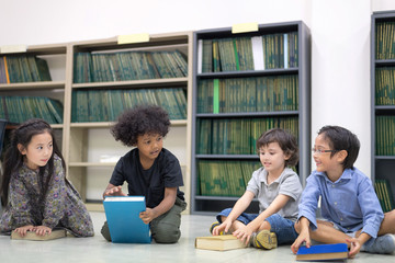 Happy kids reading on the floor, Education lifestlye in the Library. Young people explore lifestlye in the Library. Development of Human Resources in Education Concept. Setup studio shooting.
