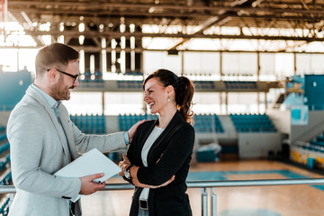 Two business people having a meeting at sports arena.