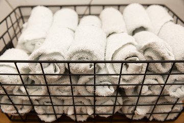 A white roll of soft toilet paper neatly hanging on a modern chrome holder on a light blue bathroom wall.