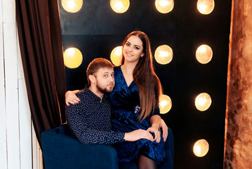 young couple in studio on background of numerous lamps