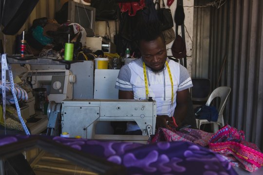 Tailor sewing clothes on sewing machine