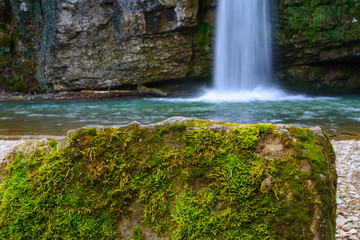 Fels mit moos und Wasserfall im hintergrund