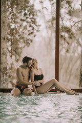 Loving couple relaxing in the spa by pool