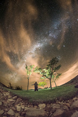 Solo man under Milky Way and clouds