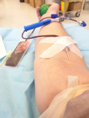 needle in the arm of and young volunteer during the blood donation