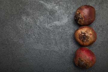 Obraz premium Juicy red beet on a black table, top view. Copy space for text.