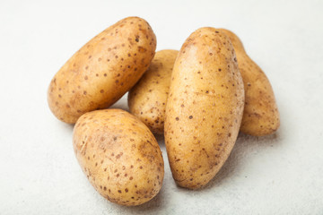 Fresh young potatoes on a white table.