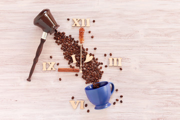 cup, coffee pot, coffee beans on a wooden background