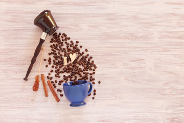 cup, coffee pot, coffee beans on a wooden background