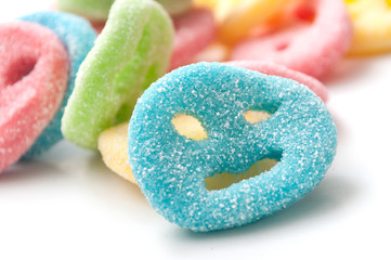 closeup of acidulous candies in shaped smiley on white background