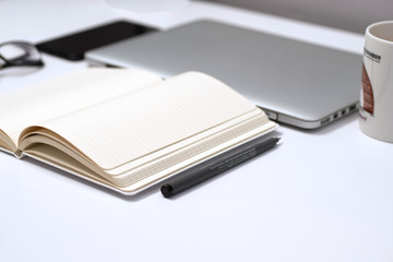 Notebook, pen and Laptop on White background