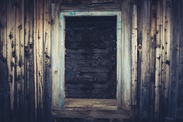 Fototapeta na wymiar Empty window opening of the old abandoned house. Blue toned image.