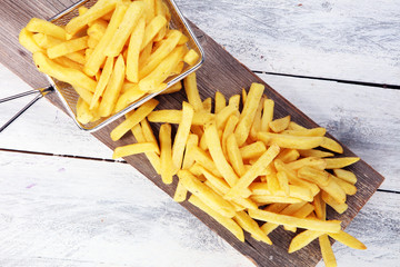 Tasty french fries on wooden table background