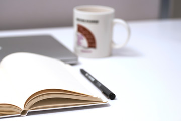 Notebook, pen and Laptop on White background
