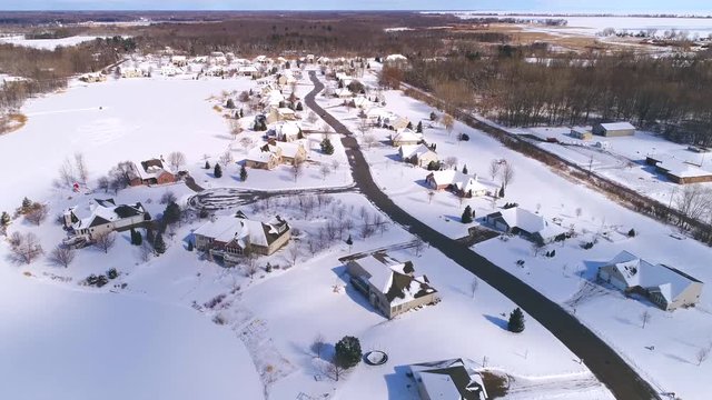 Beautiful Northern Wisconsin homes with pine trees under fresh snow, aerial view.
