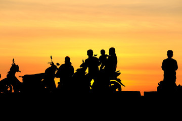 Fototapeta na wymiar Silhouette people and family on motorcycle at sunset, silhouette photo