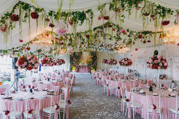 Beautiful decoration of the wedding banquet under the awning in pink, burgundy and white tones....