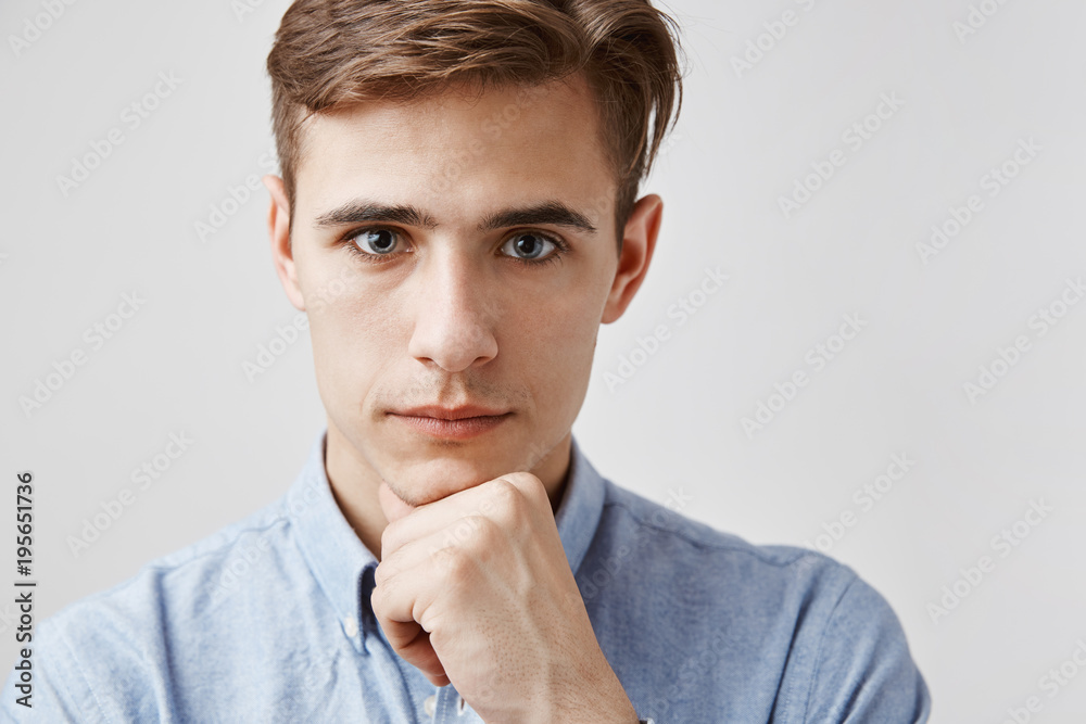 Wall mural Young handsome guy looks to the camera with kind eyes. Sister wanted to tell him something privately. Girl wants him to know first that she is getting married. Parents do not know yet