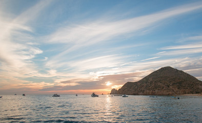 Fototapeta na wymiar Fishermans sunrise view of fishing boat going out for the day past Lands End in Cabo San Lucas in Baja Mexico
