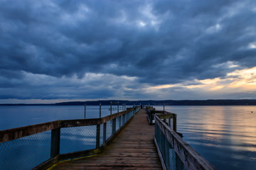 Fototapeta na wymiar gathering storm clouds over wood dock