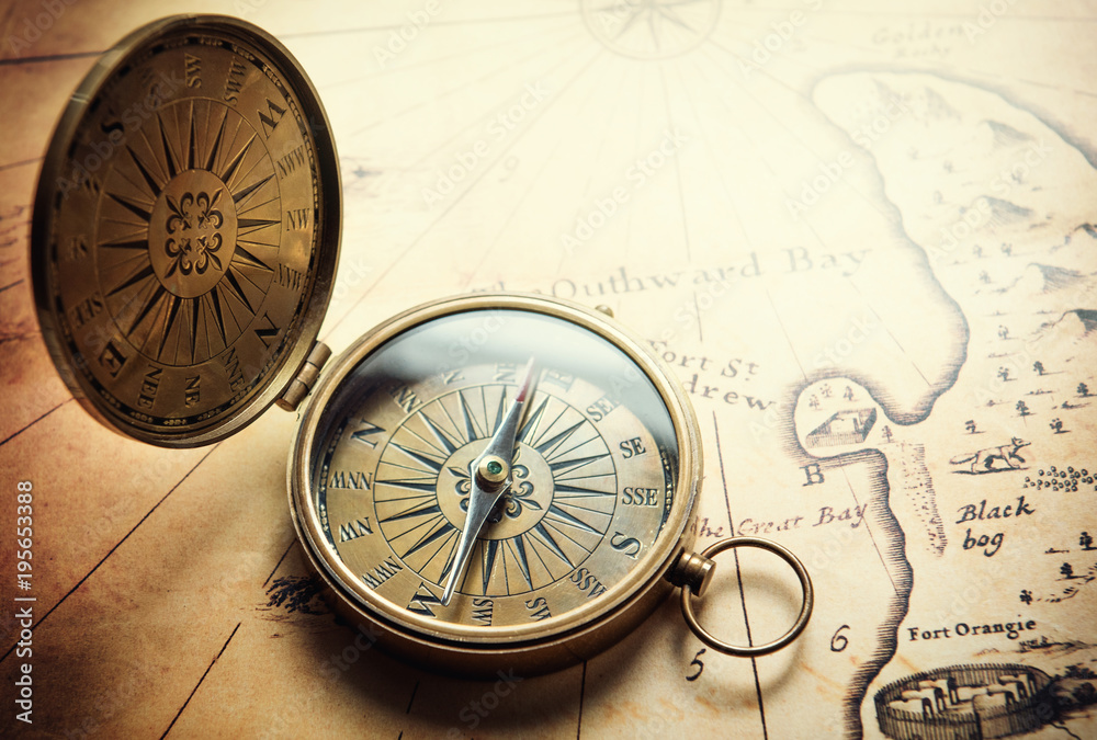 Poster old vintage retro compass on ancient map background. travel geography navigation concept background.