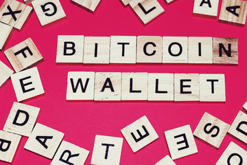 Wooden blocks on a red background spelling words Bitcoin Wallet