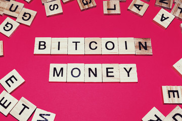 Wooden blocks on a red background spelling words Bitcoin money