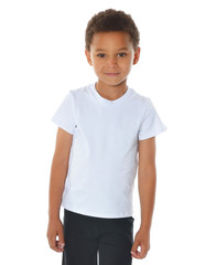 Cute boy in white t-shirt and black shorts on white background. Sport children. Atlethic kids. fitness boy. Mixed kids. Smiling boy.  © Aksinia