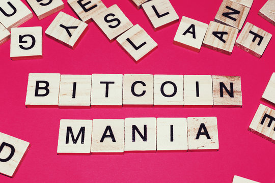 Wooden blocks on a red background spelling words Bitcoin mania