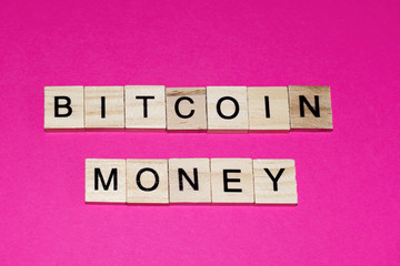 Wooden blocks on a pink background spelling words Bitcoin money