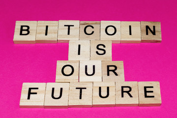 Wooden blocks on a pink background spelling words Bitcoin Is Our Future
