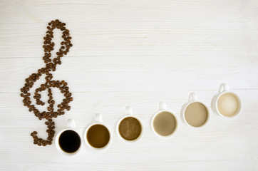 Coffee notes. Fried coffee grains in the form of a treble clef, six cups of different coffee as...