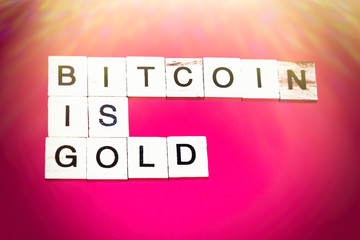 Wooden blocks on a red background spelling words Bitcoin Is Gold